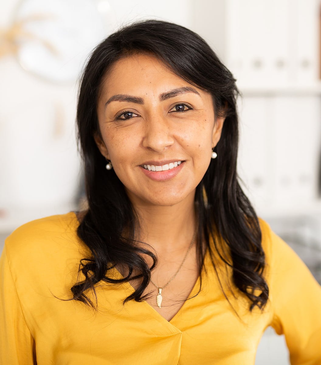 Woman smiling in living room Woman smiling in living room wearing yellow shirt