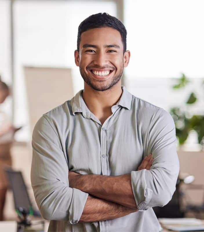Restorative page content image 2 Younger man wearing white button up with arms folded smiling